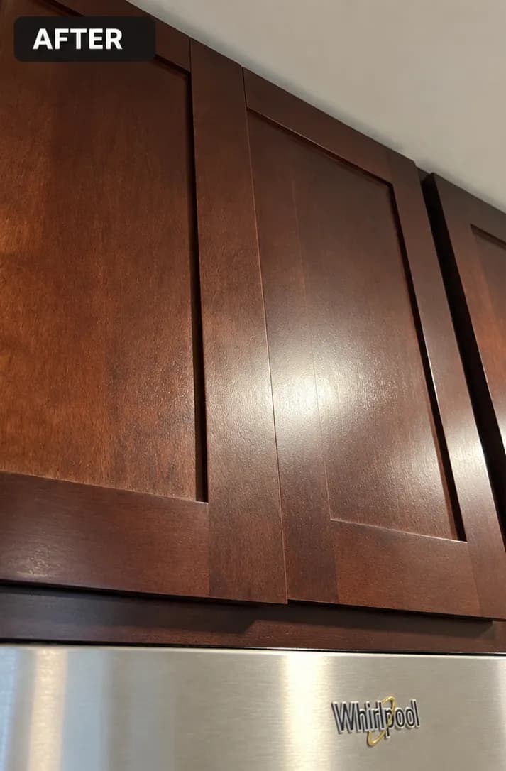 Modern kitchen cabinetry with rich wood finish above a stainless steel Whirlpool appliance.
